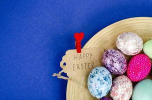 huevos de pascua hechos a mano decorados para la temporada navideña con fondo azul. concepto abstracto mínimo creativo. foto de estudio