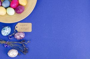 Festive Easter table setting with painted eggs on blue background. Space for text. Studio Photo