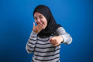 Portrait of muslim girl wearing hijab laughing hard photo