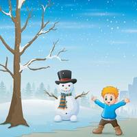 A boy standing near the snowman in winter landscape vector