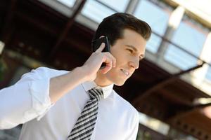 Businessman using a smart phone in an office building photo