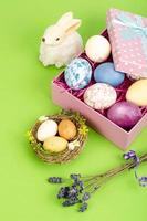 Multicolored eggs in open gift box. Concept of the Happy Easter holiday, greeting card template. Studio Photo