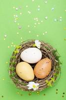 Top view of color easter haqndmade eggs and nest flatlay. Trendy minimal design spring background. Space for text. Stuio Photo