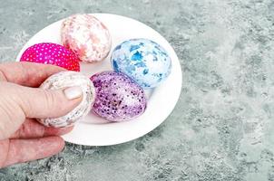 Female hand holding brightly colored easter eggs. Studio Photo