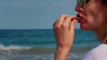 Woman eating potato chips at seaside video