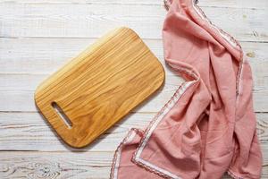 wooden empty cutting board and tablecloth on wooden background top view photo