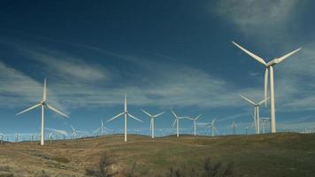 Wind turbines turn against a blue sky. video