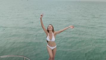 hermosa mujer en bikini blanco, chica feliz despreocupada gratis en un velero, tiro en cámara lenta en 4k video