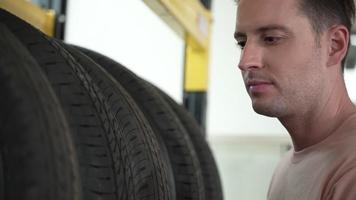 dipendenti o clienti stanno visualizzando pneumatici. acquistare ricambi auto e ottenere servizi di ispezione del veicolo in garage, scegliere un nuovo pneumatico per auto video