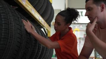 empleados o clientes están viendo neumáticos. compre repuestos de automóviles y obtenga servicios de inspección de vehículos en el garaje de automóviles, elija un neumático nuevo para el automóvil video