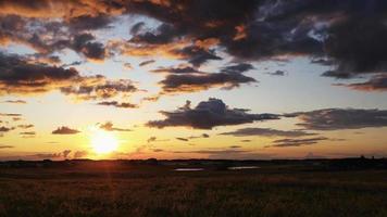vídeo de lapso de tiempo al atardecer. timelapse de la puesta del sol sobre el pasto del agricultor en las praderas de alberta, canadá. cielo azul con nubes en movimiento. praderas canadienses video