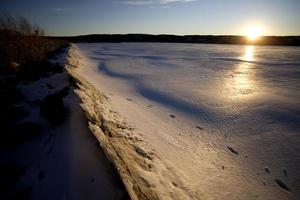 puesta de sol en el lago del norte en invierno foto