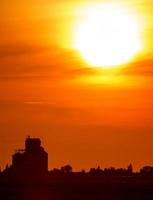 silueta al atardecer con elevador de granos foto