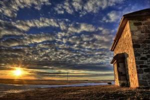 casa de piedra puesta de sol foto