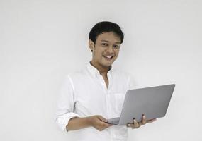 Young asian man is smile and enjoy when working at home with laptop computer. Work from home concept. photo