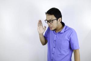 Cierra el retrato de un joven asiático gritando fuerte y enojado con el brazo en la cara aislado en blanco foto