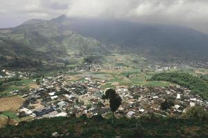 Aerial view of Dieng Plateau with town and hill in background photo