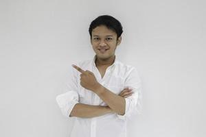 Smile of Young Asian man in white shirt with hand point on empty space photo