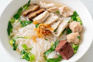 Vietnamese Rice Noodles Soup with Vietnamese Sausage served vegetables and crispy onion photo