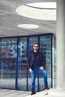 Trendy guy with blue jeans and leather jacket photo