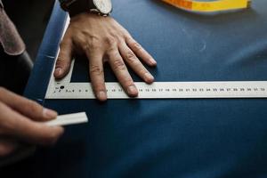 tailor working in his workshop draws photo