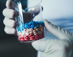 Doctors hand holding laboratory glass photo