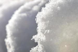 tapas de nieve blancas y claras iluminadas desde atrás por el sol de la mañana de cerca foto