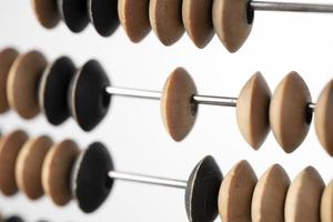 Wooden knuckles on the metallic pins of old abacus close up photo