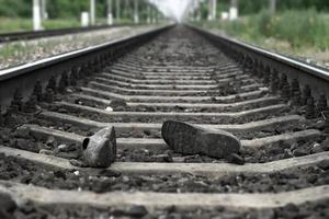 Accident on railway. Rubber boots lying on railway track photo