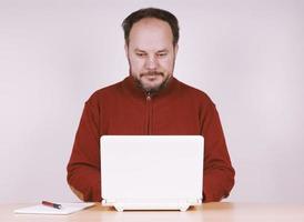 hombre adulto medio que usa una computadora portátil netbook para mantenerse conectado foto