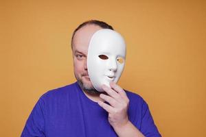 man taking off mask revealing face and identity photo