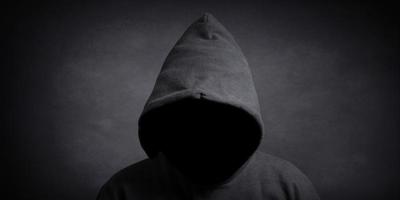 faceless person wearing black hoodie hiding face in shadow photo