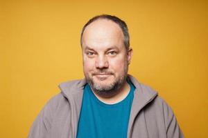 casual chubby mature man against yellow background photo