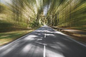 carretera rural vacía de dos carriles a través del bosque con desenfoque de movimiento foto