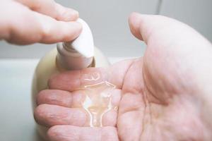 using liquid soap dispenser before washing hands photo