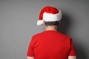 rear view of man wearing santa hat and red t-shirt photo