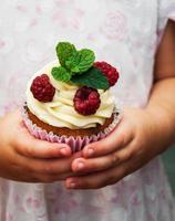 Little girl holding cupcake