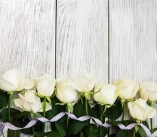 White roses on a wooden table photo