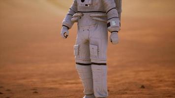 astronaut op het oppervlak van Mars. rode planeet bedekt met gas en steen video