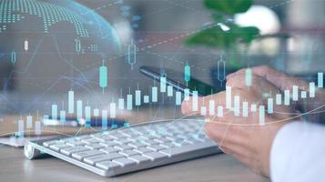 Concept of international internet trading is represented by a double exposure of graphs and financial data, as well as a workplace with a computer background photo