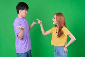 Young Asian couple posing on green background photo