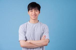 joven asiático posando sobre fondo azul foto