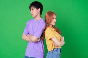 joven pareja asiática posando sobre fondo verde foto