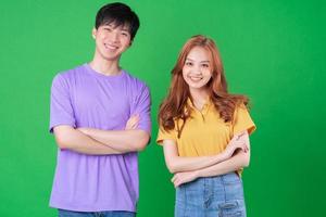 Young Asian couple posing on green background photo