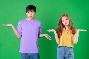 Young Asian couple posing on green background photo