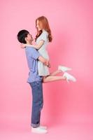 Young Asian couple posing on pink background photo