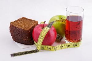 Rye bread apples and juice in  glass on a white background with a measuring tape photo