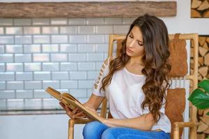 beautiful young woman reading a book at home photo