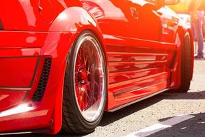 Red sports tuned car rear view of the wheel, close-up . photo