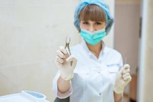woman doctor in mask with tools in hand photo